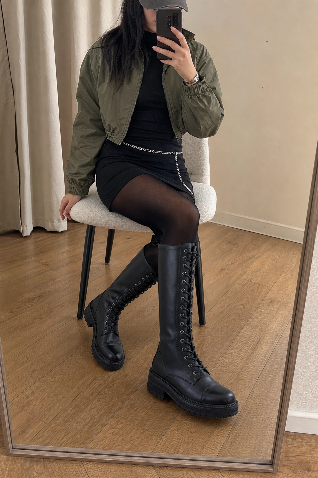 Woman wearing CURFEW boots in a seated apartment mirror selfie